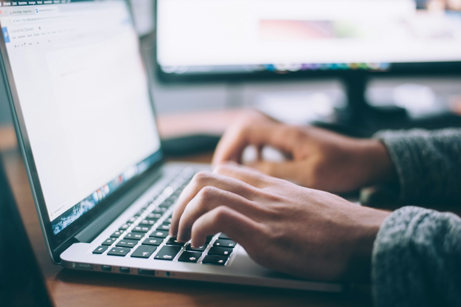 Hands typing on a laptop while building and testing a website